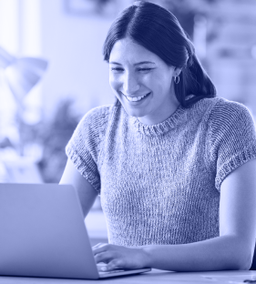 A women smiling and using her computer