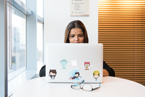 woman on laptop computer with stickers